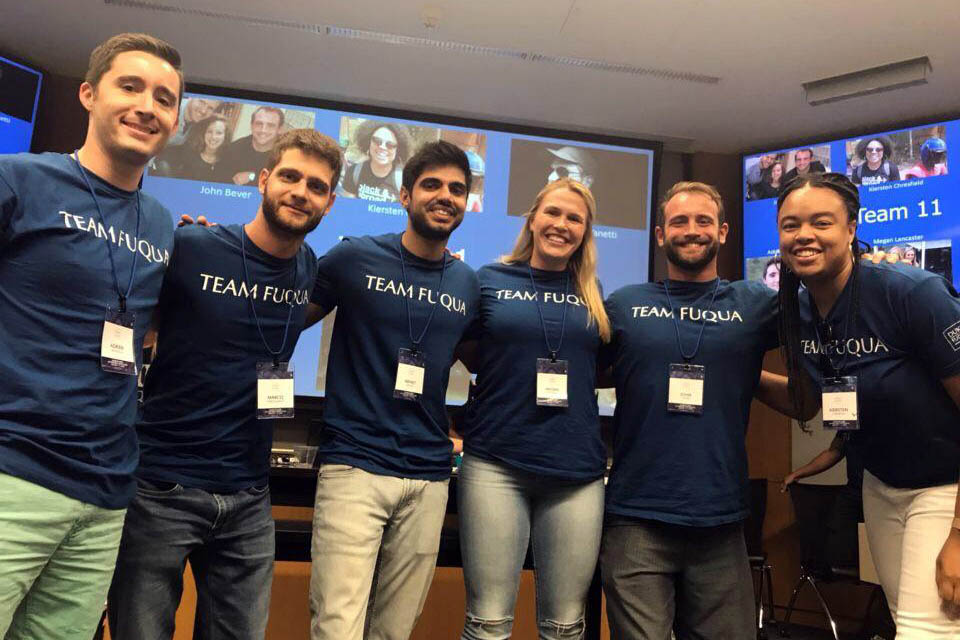 6 students in "Team Fuqua" T-shirts post for a group photo; international applicants