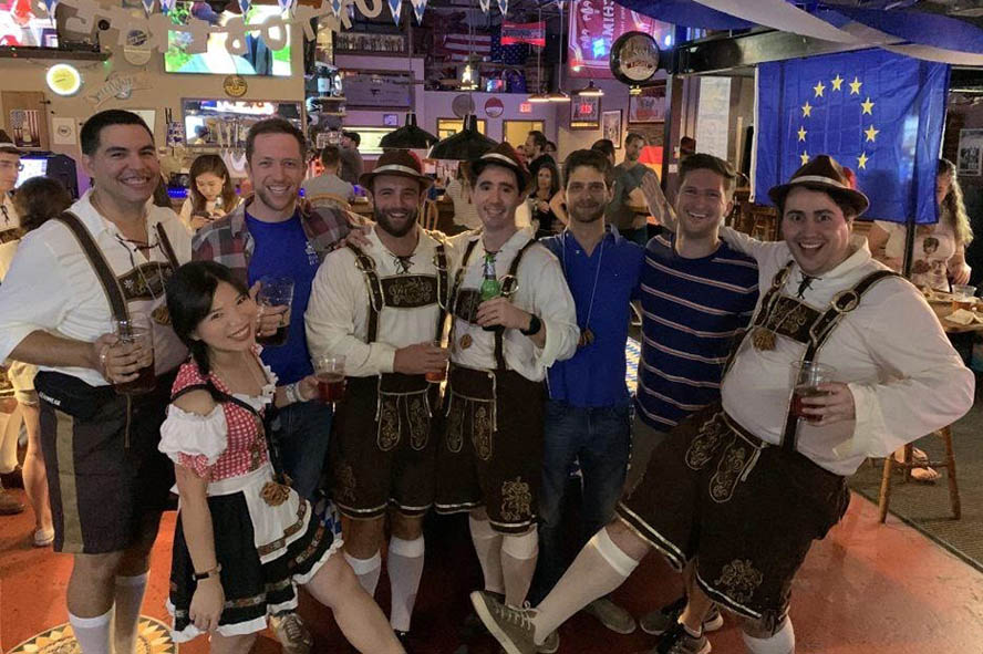 8 students, 5 of whom are dressed in traditional Oktoberfest apparel, post for a photo in a Durham bar; advice for European applicants