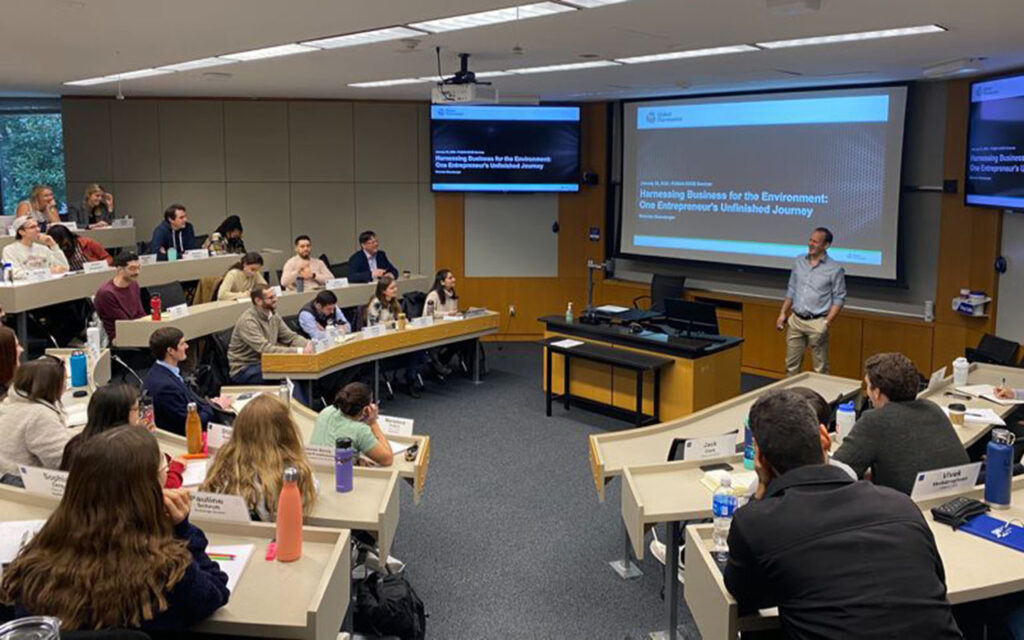 Nicholas Eisenberger at the front of a Fuqua classroom presenting to students in EDGE seminar. Most seats are filled.
