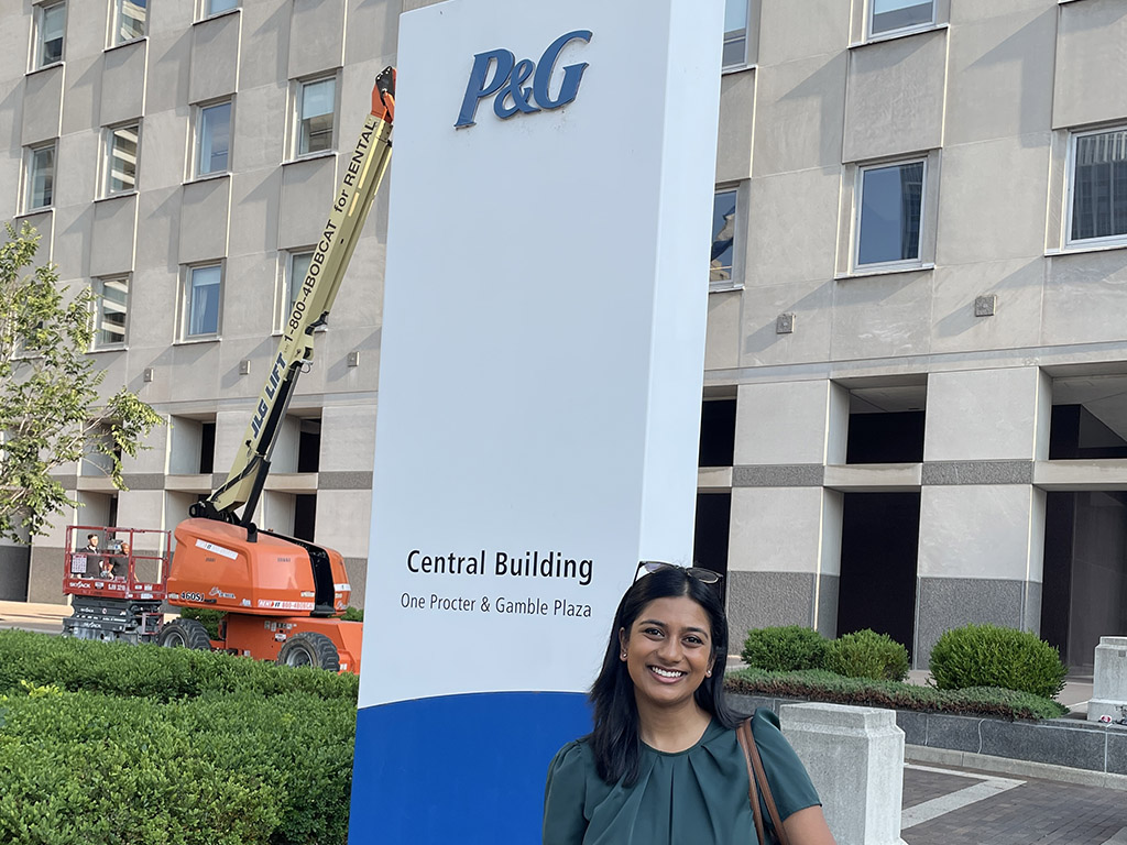 Anandi Rahman, an MBA student at Duke University's Fuqua School of Business, stands in front of P&G sign
