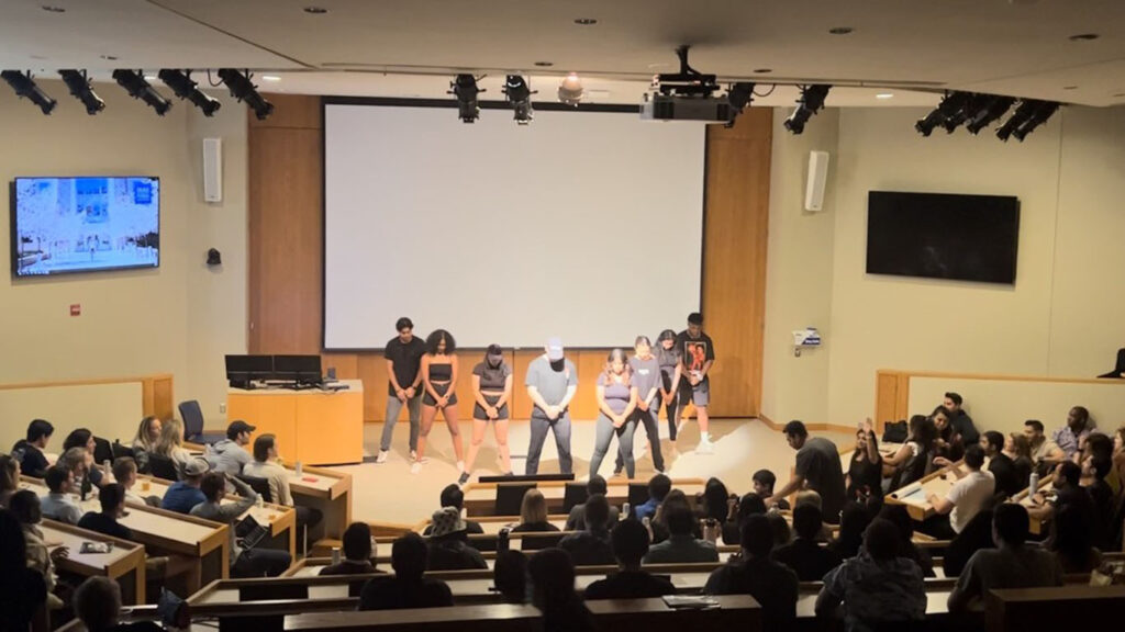The Fuqua Dance Community performing in front of a crowd of students at Duke university's Fuqua School of Business