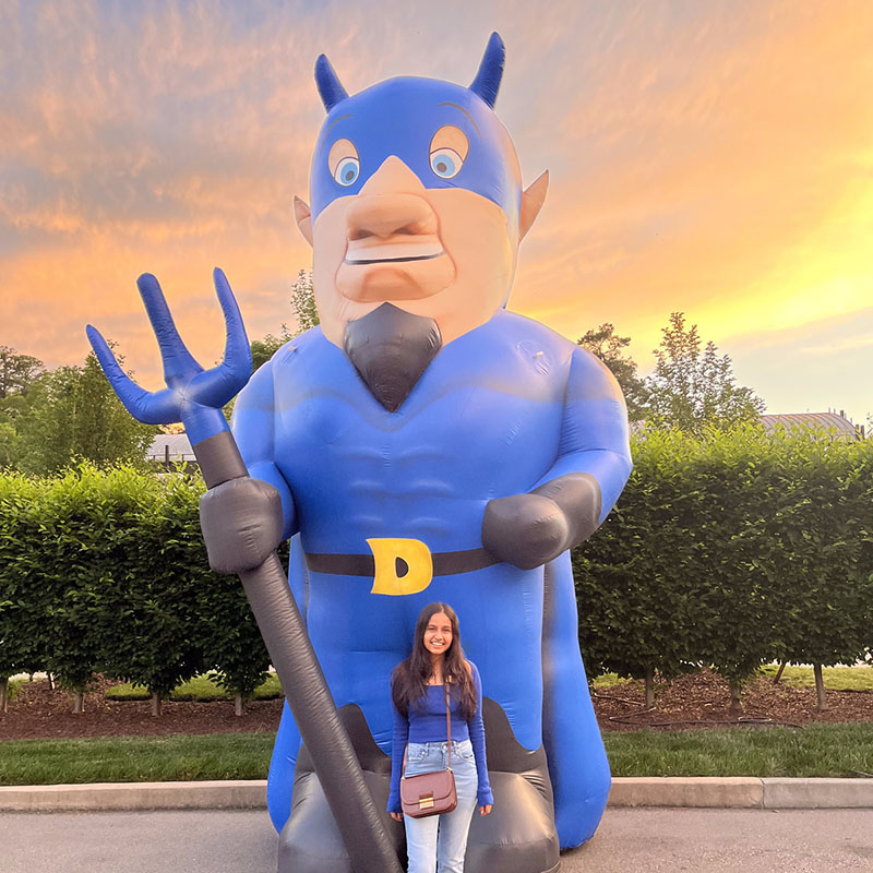 Aditi Achrekar, a Duke Fuqua MMS alumna, with a blow-up Duke Blue Devil about 20 feet tall