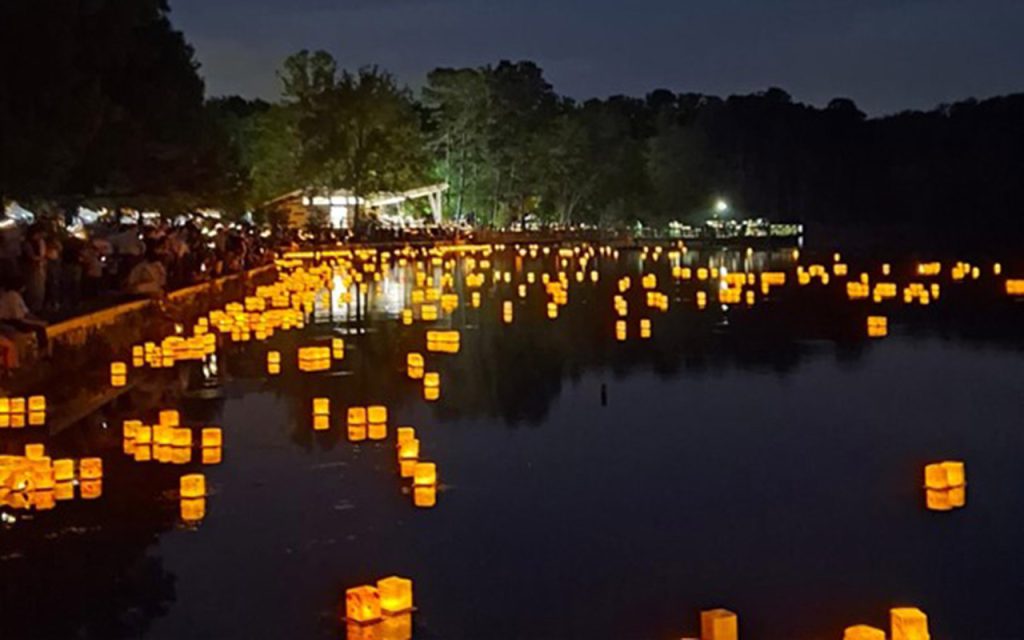 Dozens of water lanterns lighting up the water at night