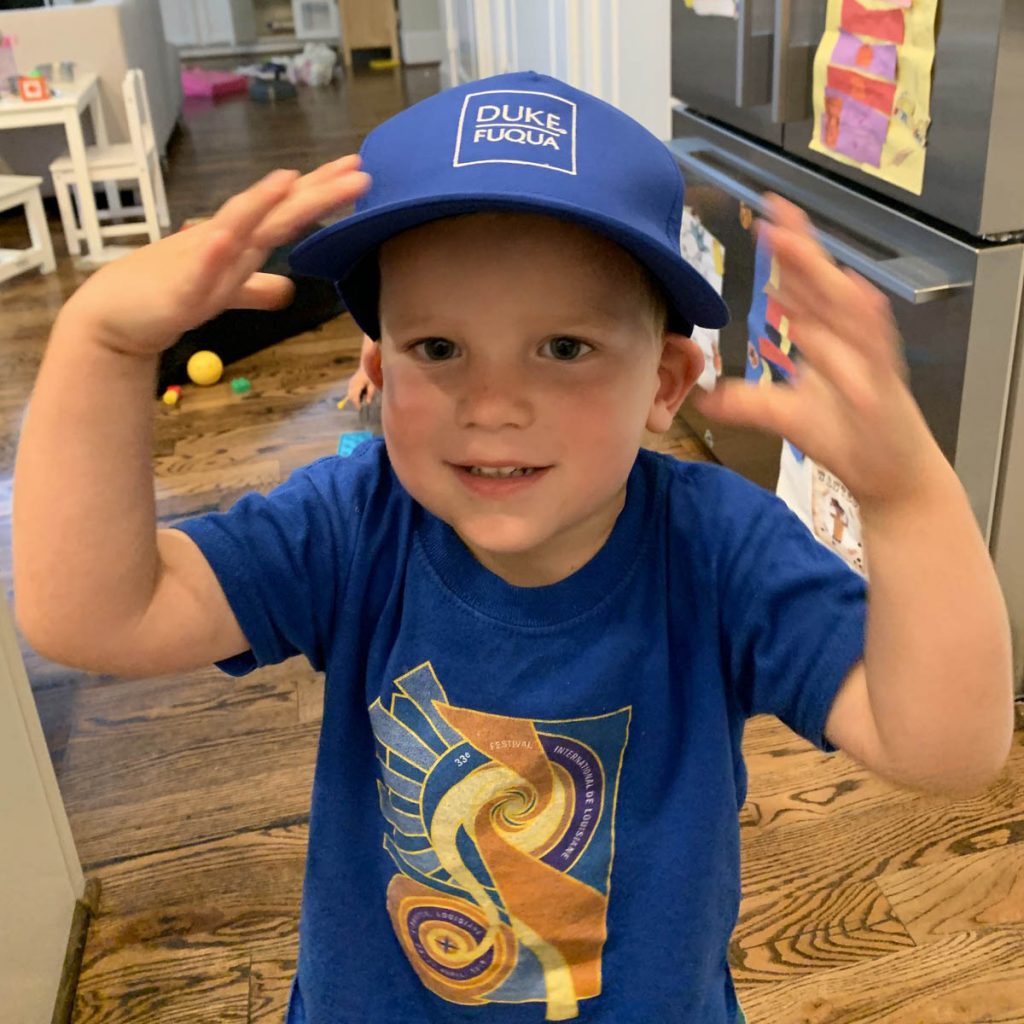 Alexander's 2-year-old son wearing a  Fuqua hat; work-life balance