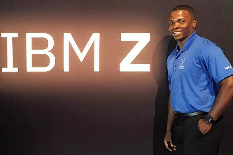 Jamal standing beside an IBM Z sign