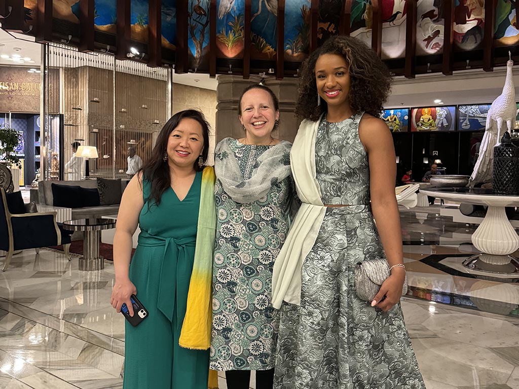 Trillion Small and two of her women classmates wearing formal attire for their final dinner of the New Delhi residency