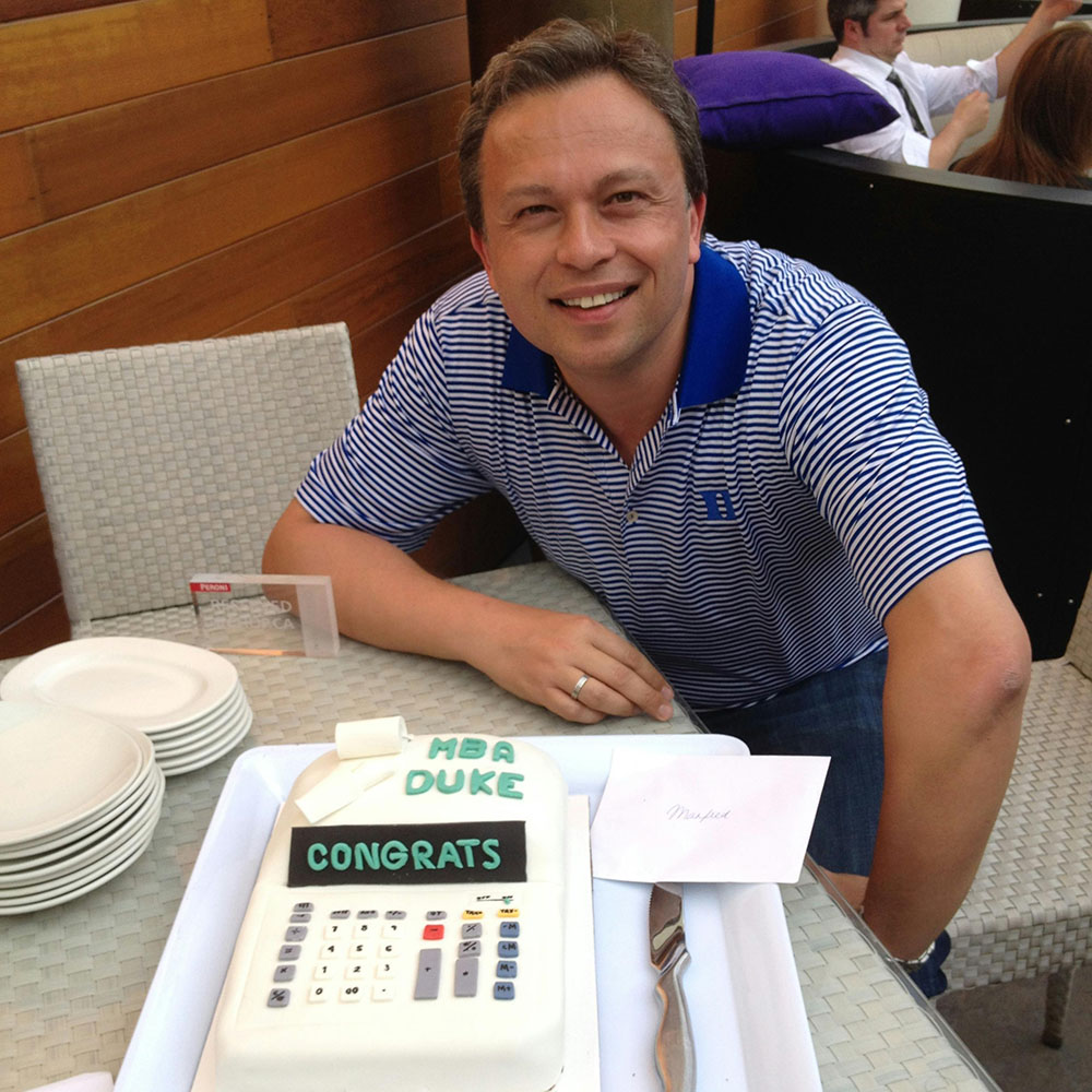 Manfred Boudreaux-Dehmer with a cake in the shape of a calculator celebrating his MBA graduation