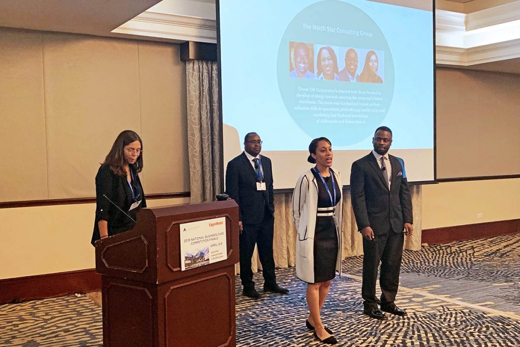 the four students in front of a room presenting during the case competition, a learning experience that took them beyond the classroom 