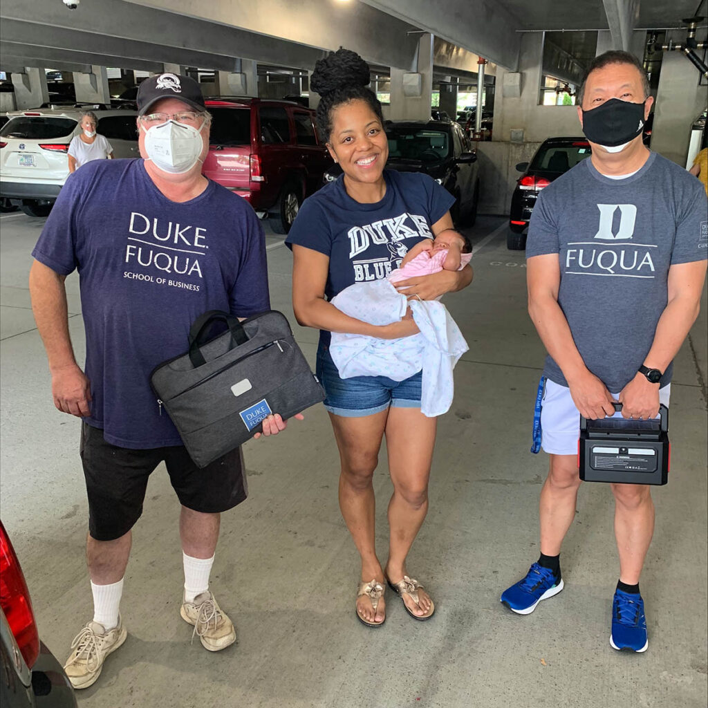 Zakiya, her infant daughter and Reese and Gordon from Fuqua's tech support team in the parking deck