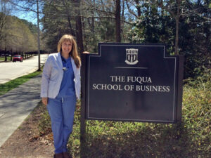 Anne Steptoe, Duke MBA entrepreneur, beside the Fuqua sign