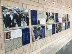 students are profiled on a display board in the hall, one of the stops during a campus visit tour
