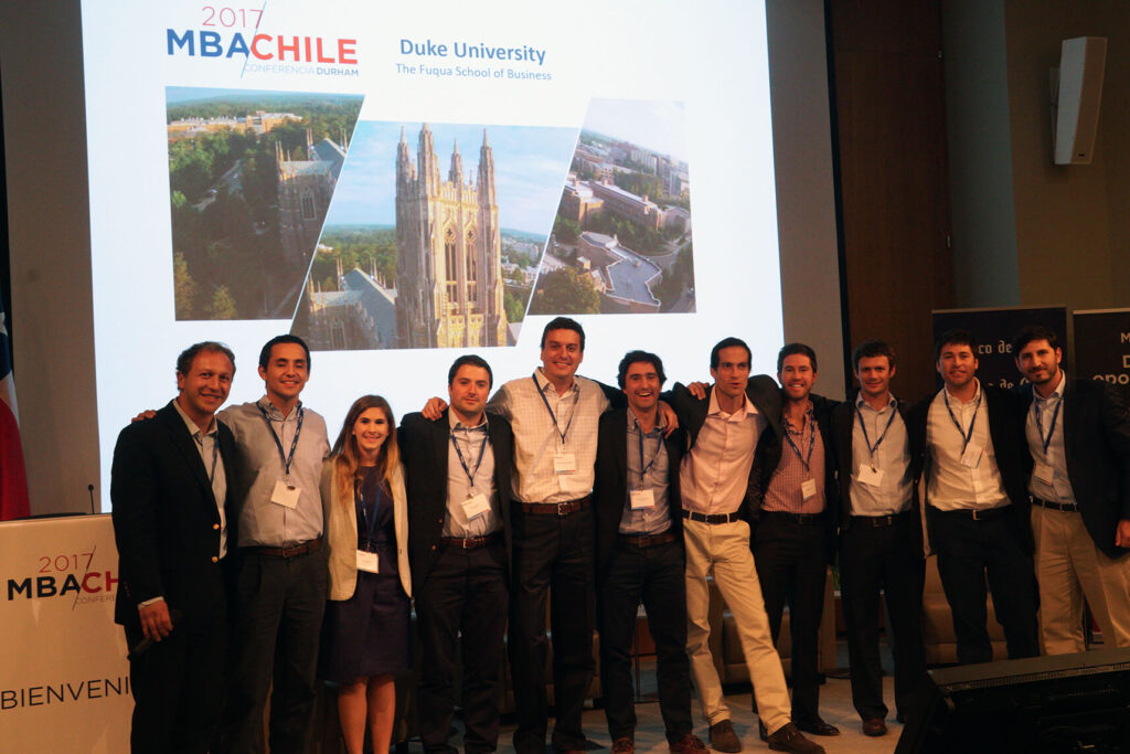 11 students posing in front of the MBA Chile auditorium stage