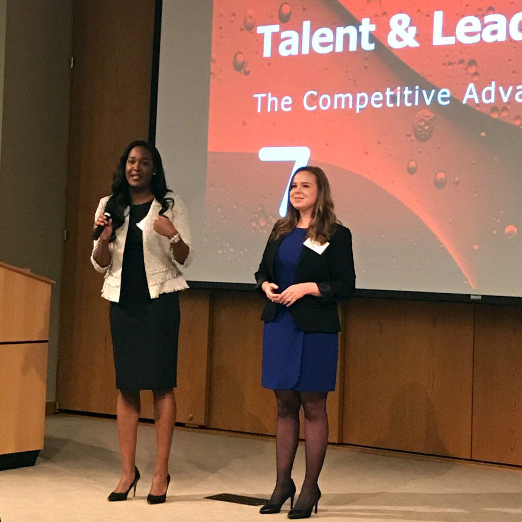 Two of the event's student organizers address the audience at the C200 women's leadership conference