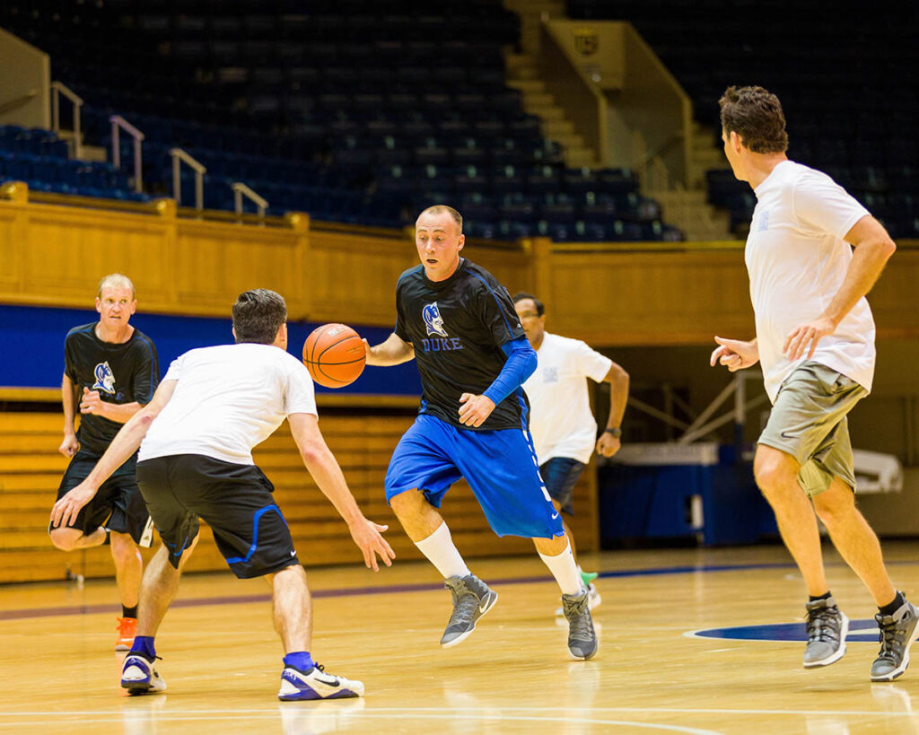 Kevin Kumlien driving down the basketball court against his buddy Steve Misuraca inside Cameron Indoor Stadium 