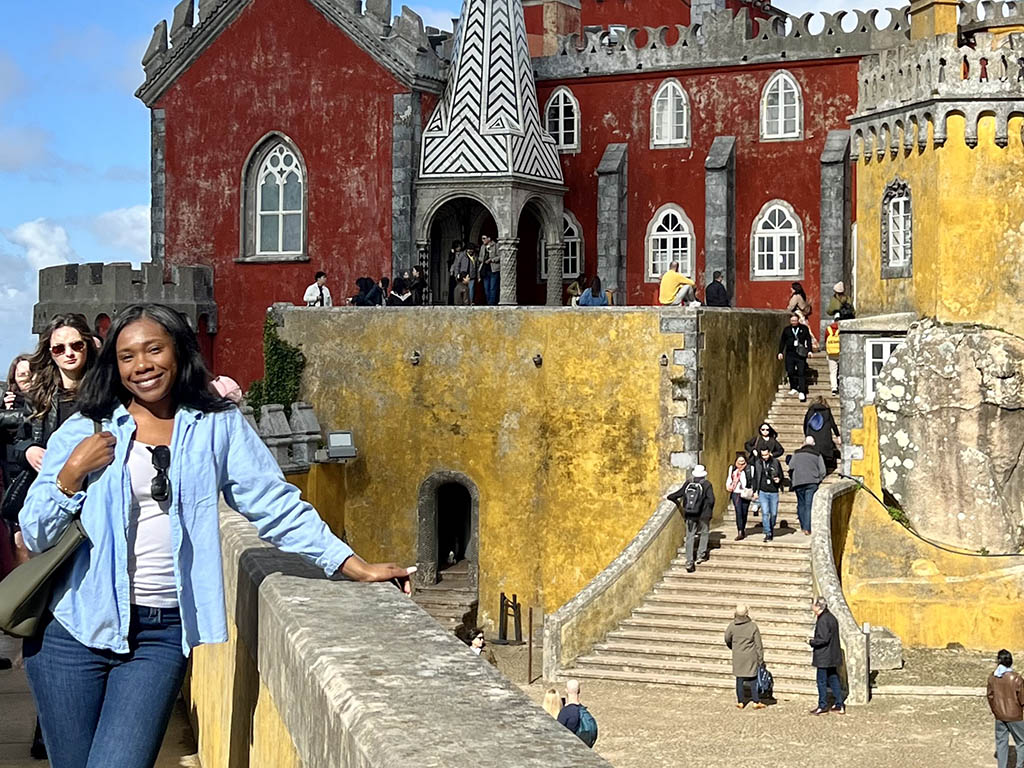 Mikhala Nelson, a student in the Daytime MBA program, stands along a half-wall on a bridge overlooking an iconic building in South Africa