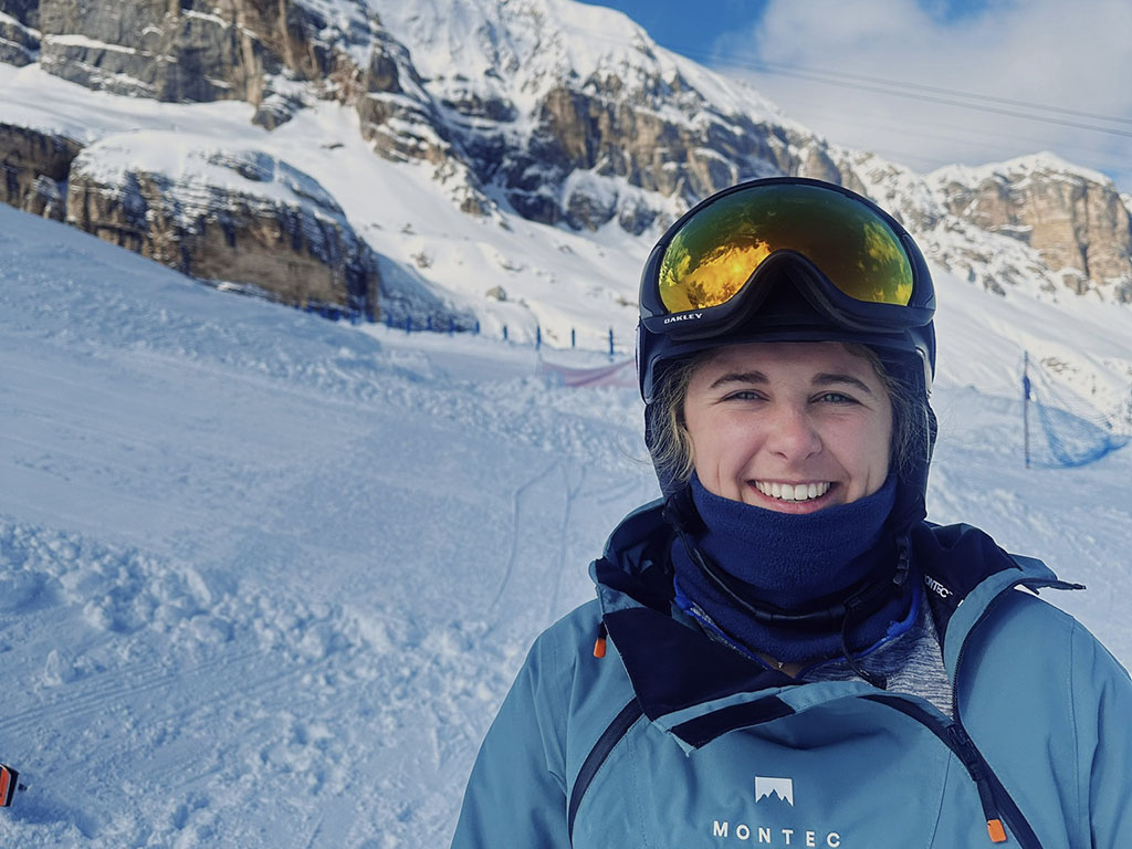 Izzy Scribano, a student in the Daytime MBA program at Duke University's Fuqua School of Business, wearing snow gear, including tinted ski goggles on a mountain 