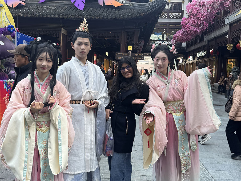Ashima Garg, an MMS: DKU student at Duke University's Fuqua School of Business, standing with three people in traditional Chinese attire