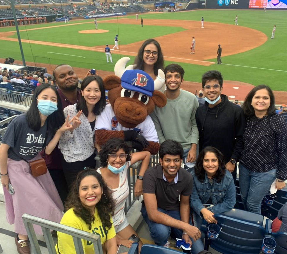 10 MQM students at a Durham Bulls game posing with the bull mascot