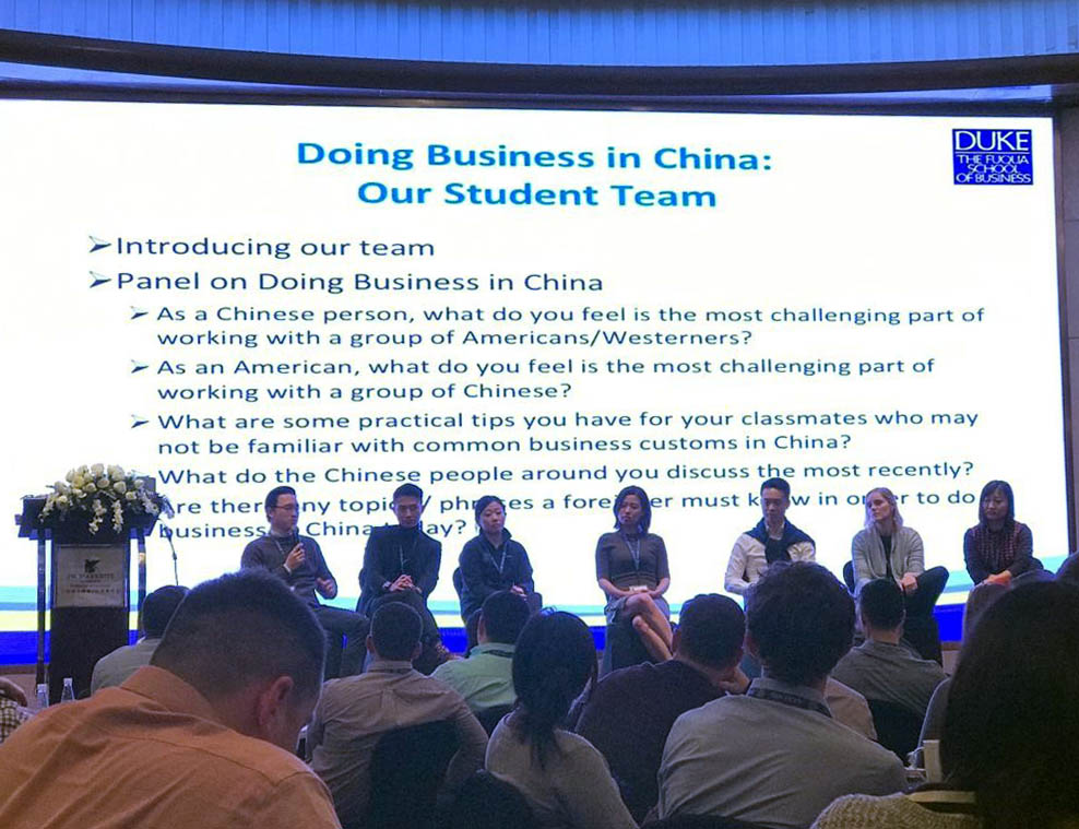 seven student seated on stage with a PowerPoint about doing business in China running behind them; key learnings
