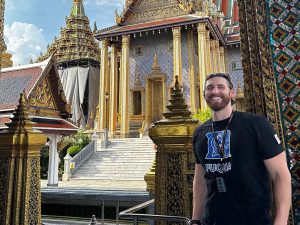 Drew Rotolo, a student in the Global Executive MBA program at Duke University's Fuqua School of Business, stands in front of the Grand Palace in Bangkok, Thailand while on a residency