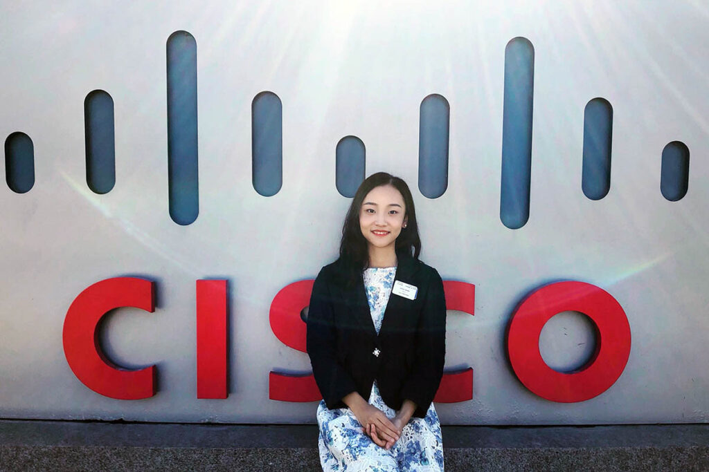 Rachel siting in front of the Cisco sign, exploring West Coast jobs