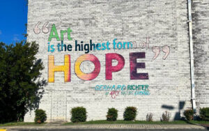 Street art on a white building that reads, "Art is the highest form of art"