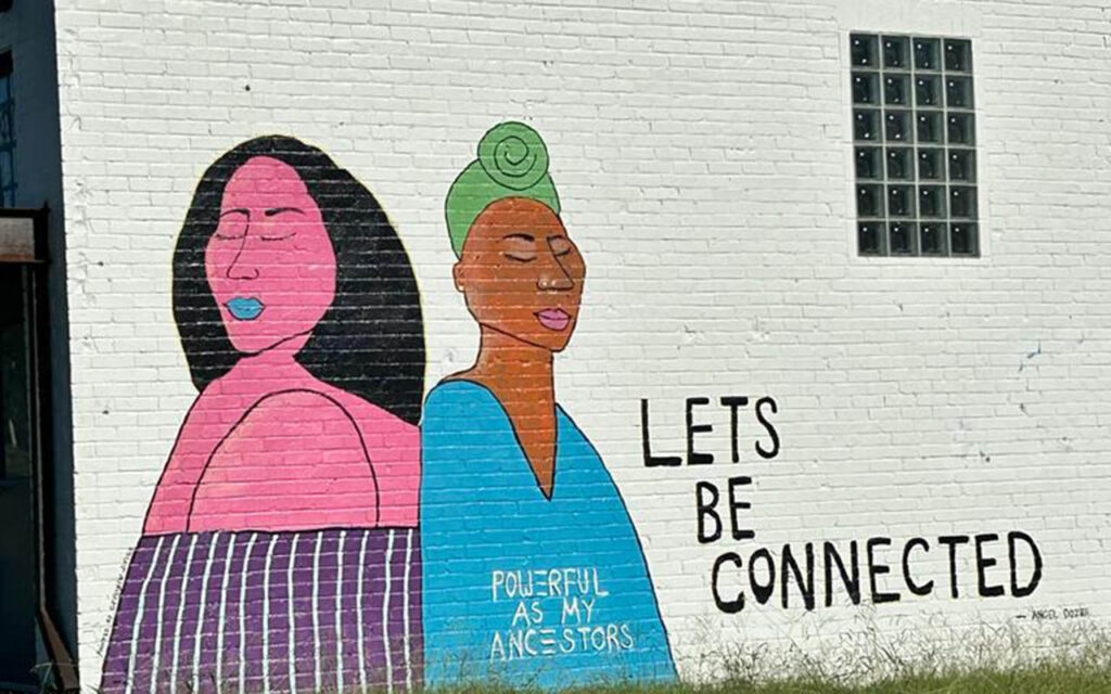 Street art portraying two women of different races and the words, "Let's be connected"