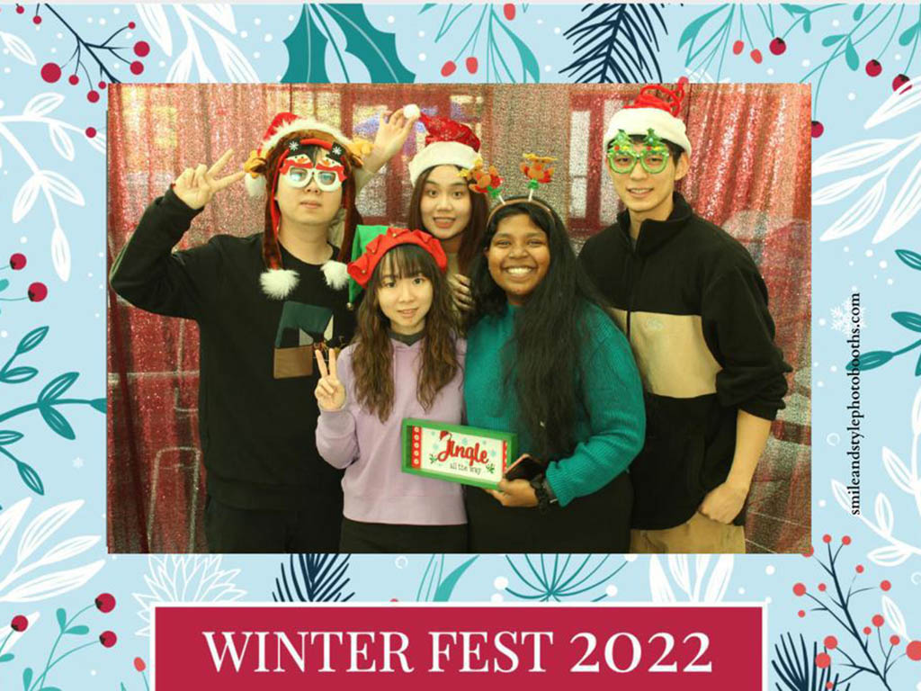 Five MQM students wearing, most wearing Santa hats, the photo is in a digital frame reading, "WinterFest 2022"