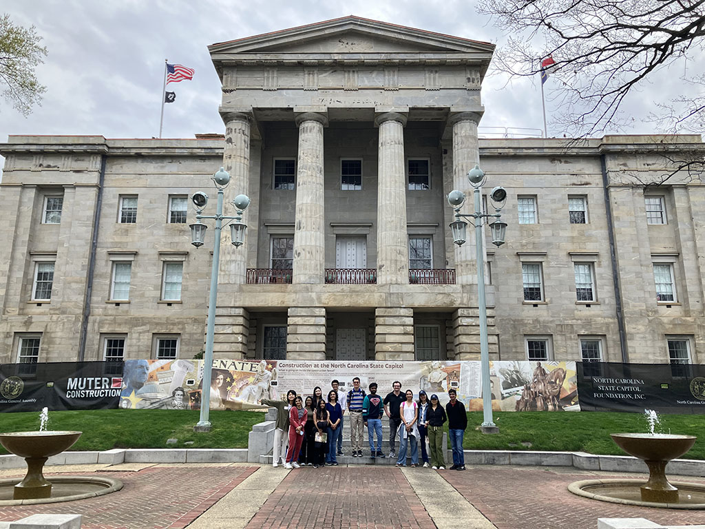 A group of the MQM: BA Class of 2024 standing in front of the North Carolina Capitol building in Raleigh, NC during a spring break daytrip