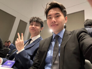 Robert Zeng and Tony Yang sitting in a conference room, both are wearing suits and name tags