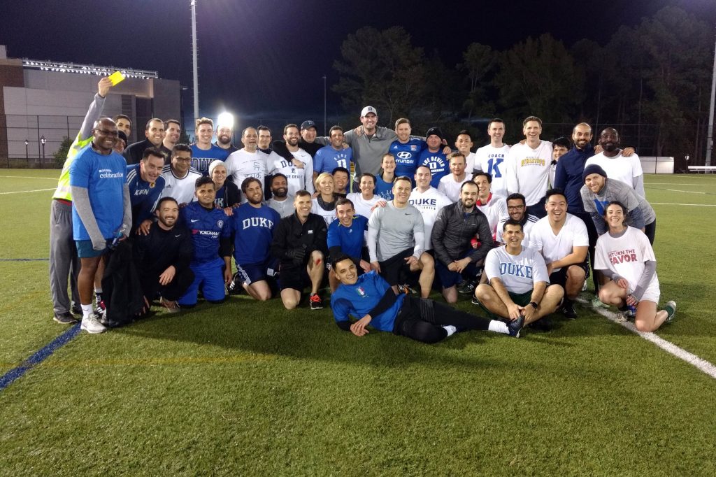 More than 30 students and faculty pose for a photo on a campus soccer field; Reflections 6 Months into the Weekend Executive MBA Program