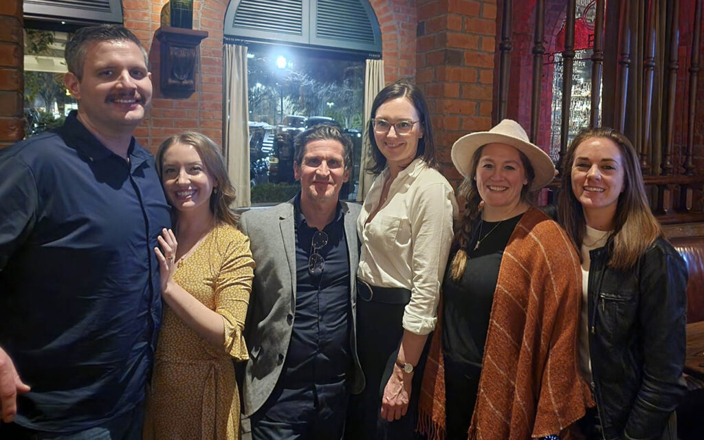 Jessica Meidinger, a graduate of the Weekend Executive MBA Class of 2025 at Duke University’s Fuqua School of Business, with her wife, as well as two classmates and their partners