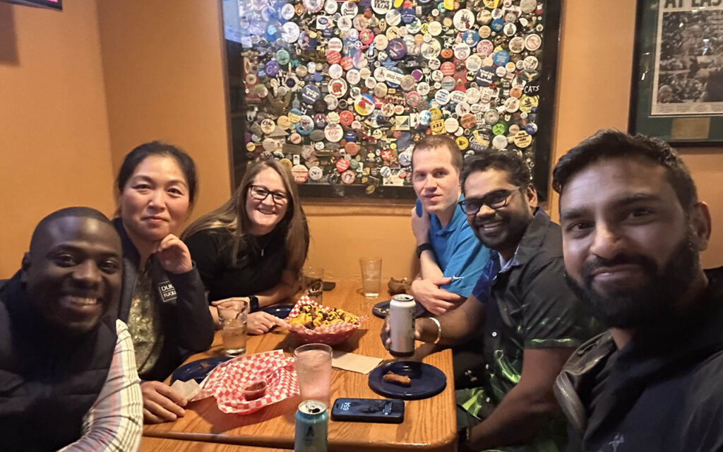 Jessica Meidinger, a graduate of the Weekend Executive MBA Class of 2025 at Duke University’s Fuqua School of Business, sitting with five of her classmates around a restaurant table