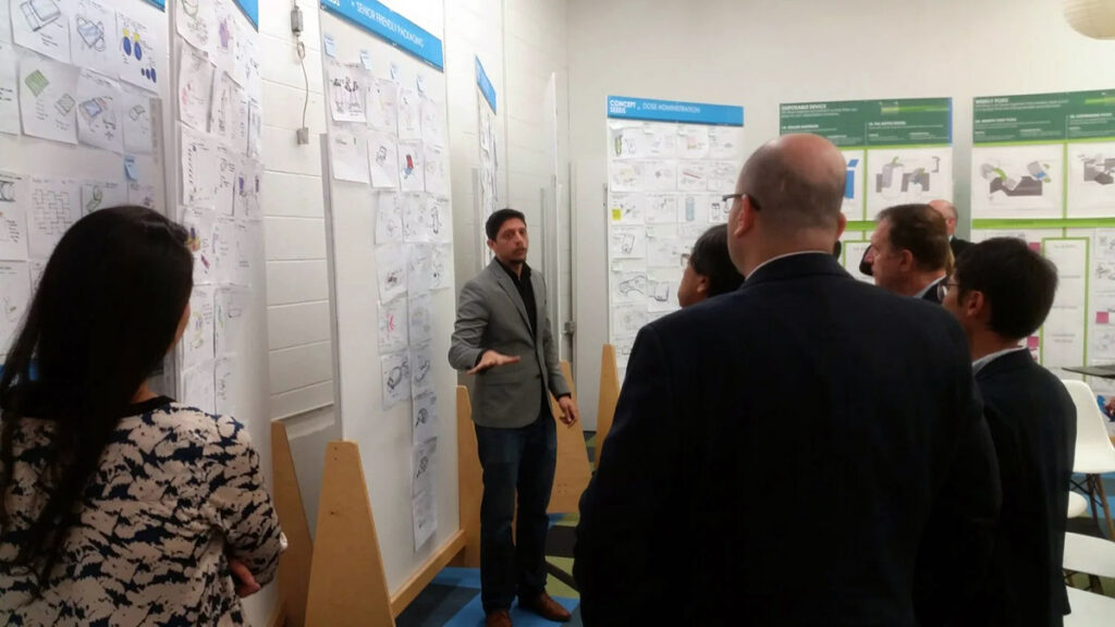 Ayan Bhandari, a student in the Weekend Executive MBA program at Duke University's Fuqua School of Business, is delivering a presentation with a display of notes behind him