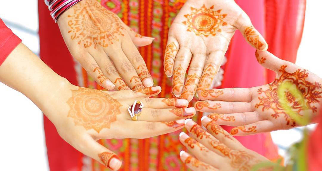 five hands with henna art together forming a circle, symbolizing family at Fuqua